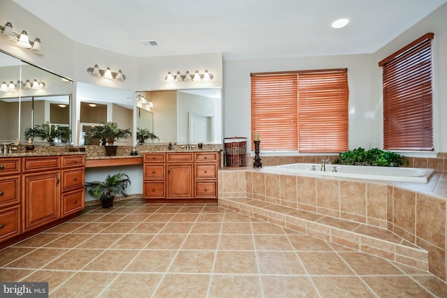 bathroom featuring tile patterned floors, visible vents, a bath, and vanity