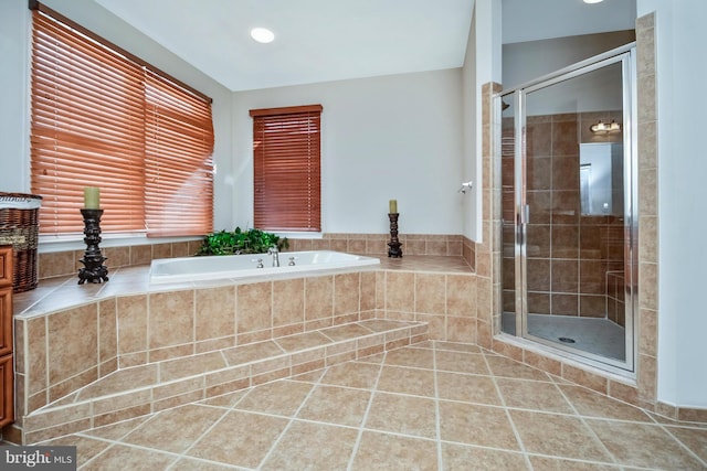 full bath with tile patterned floors, a bath, and a stall shower