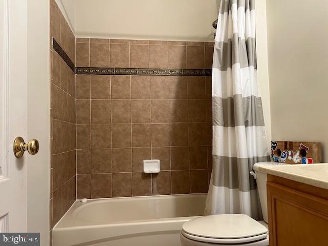 bathroom featuring toilet, vanity, and shower / tub combo