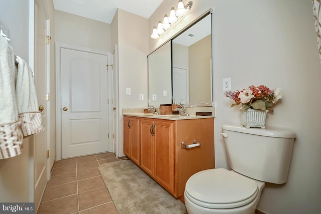 full bath featuring tile patterned floors, toilet, double vanity, and a sink