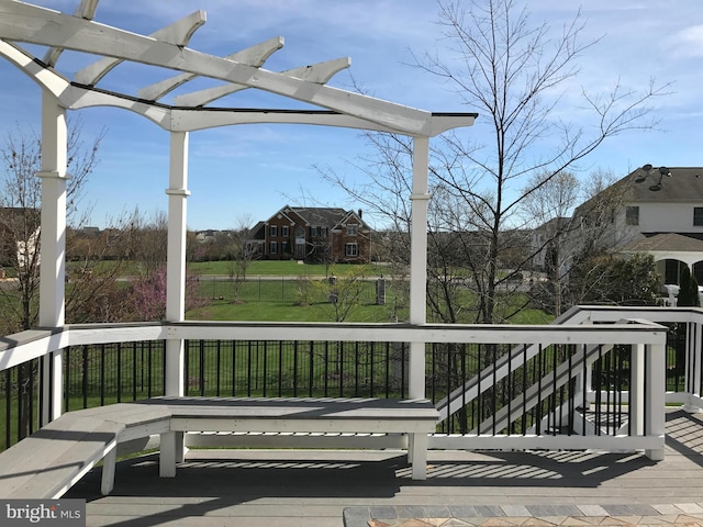 wooden deck with a lawn and a pergola