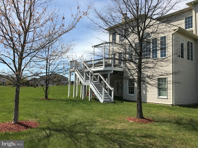 view of front facade featuring a wooden deck, stairs, and a front lawn