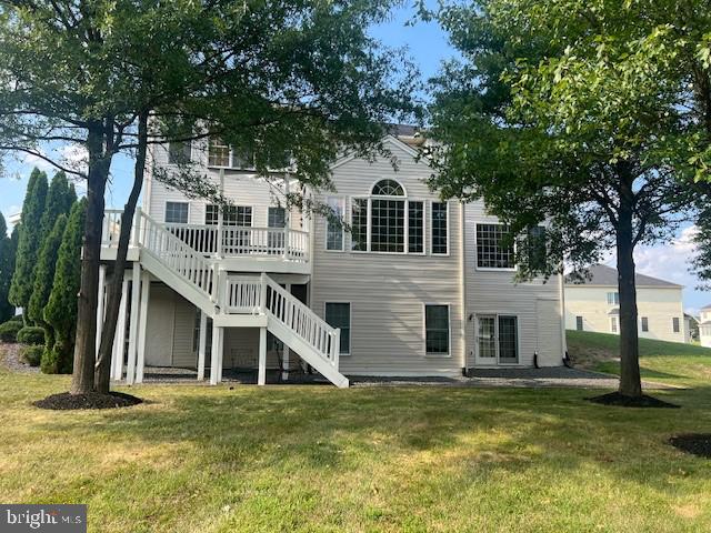 rear view of house featuring a yard and a deck