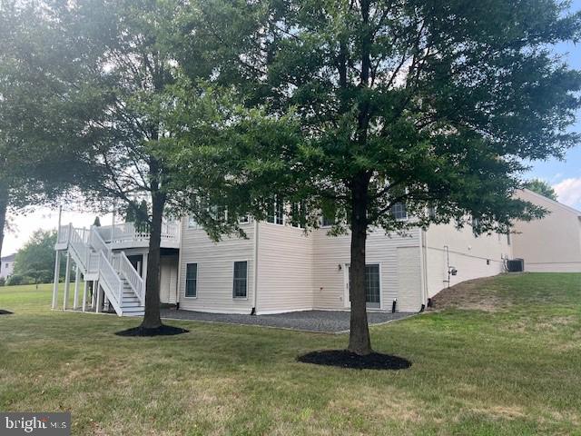 exterior space featuring a yard, a deck, and stairs