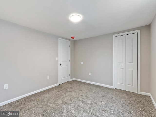 unfurnished bedroom with carpet flooring and a closet