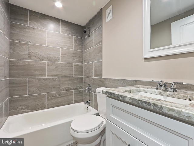 full bathroom with toilet, vanity, and tiled shower / bath