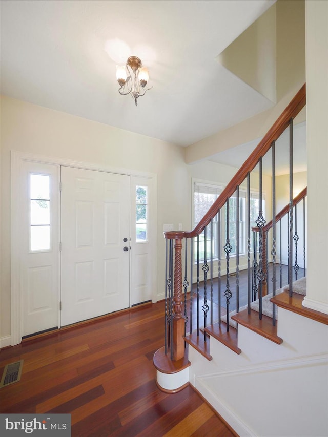 entrance foyer with a notable chandelier and hardwood / wood-style flooring