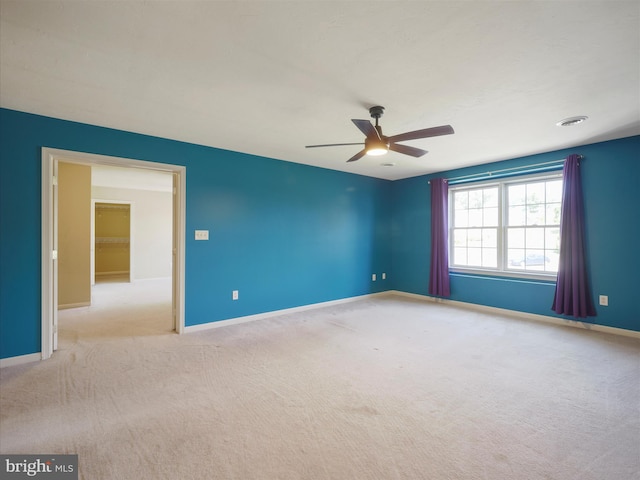 spare room with ceiling fan and light colored carpet