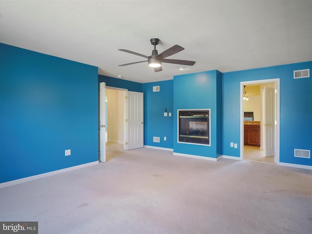 unfurnished living room with ceiling fan and light carpet