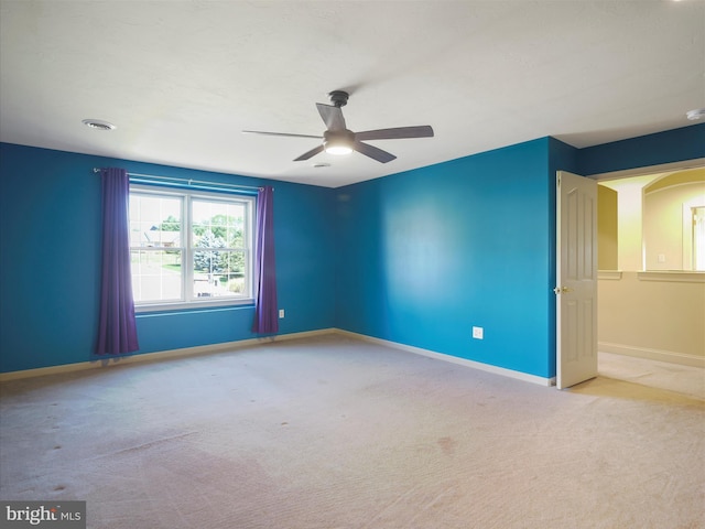 carpeted spare room featuring ceiling fan