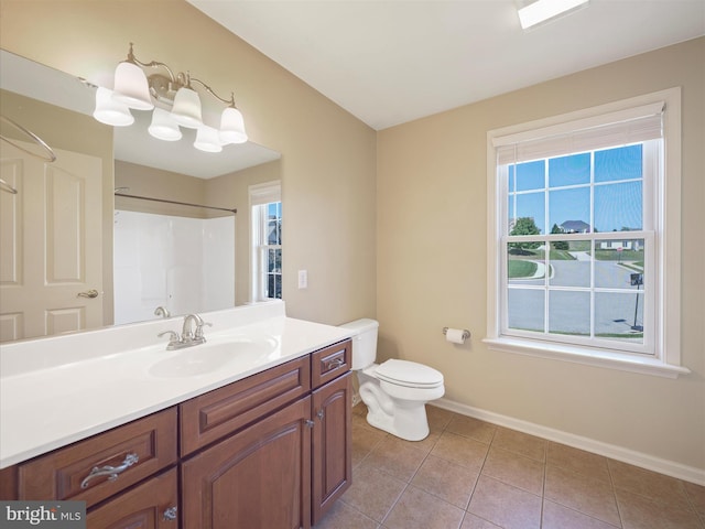 bathroom featuring vanity, toilet, plenty of natural light, and tile patterned flooring