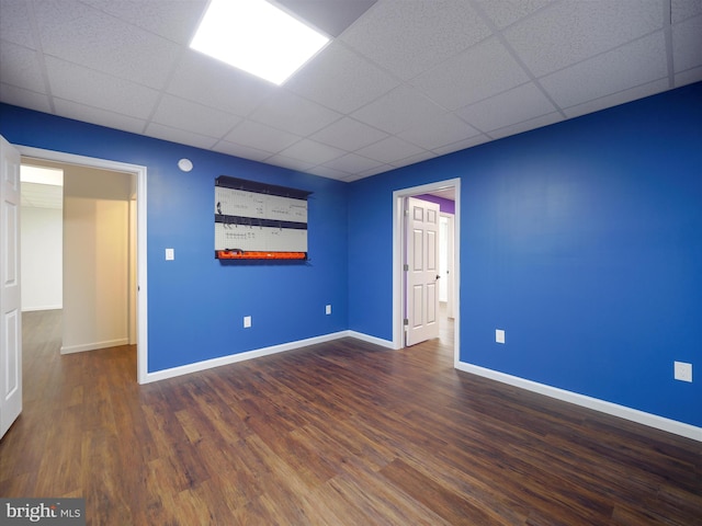 spare room featuring hardwood / wood-style floors and a drop ceiling