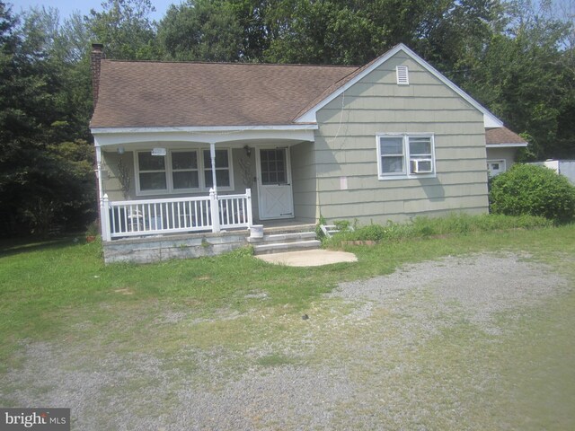 view of front of property with a porch, a garage, and a front yard