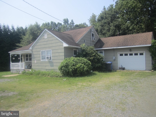 view of front facade with a garage, a porch, and a front lawn