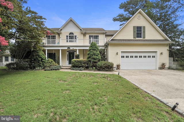 view of property with a front yard, a balcony, a porch, and a garage