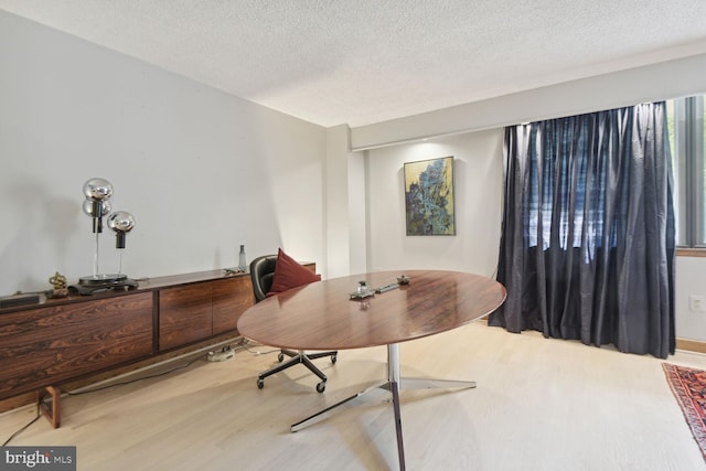 office area with light wood-type flooring and a textured ceiling