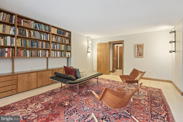 sitting room featuring a textured ceiling and light wood-type flooring