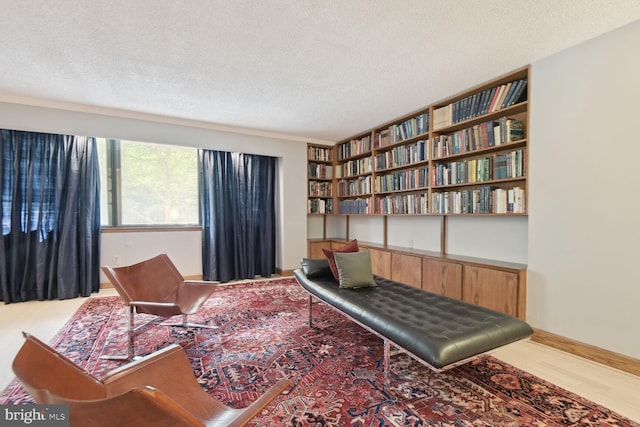 sitting room with wood-type flooring and a textured ceiling