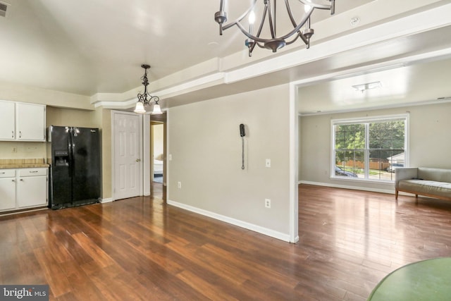 interior space featuring decorative light fixtures, an inviting chandelier, white cabinets, black fridge with ice dispenser, and hardwood / wood-style flooring