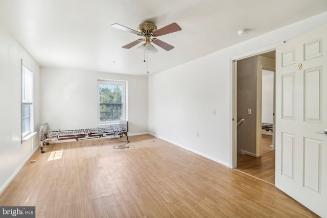 spare room with ceiling fan and light wood-type flooring