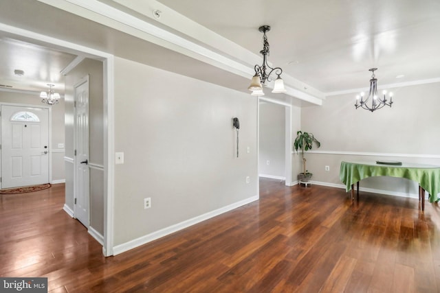 spare room with a notable chandelier, crown molding, and wood-type flooring