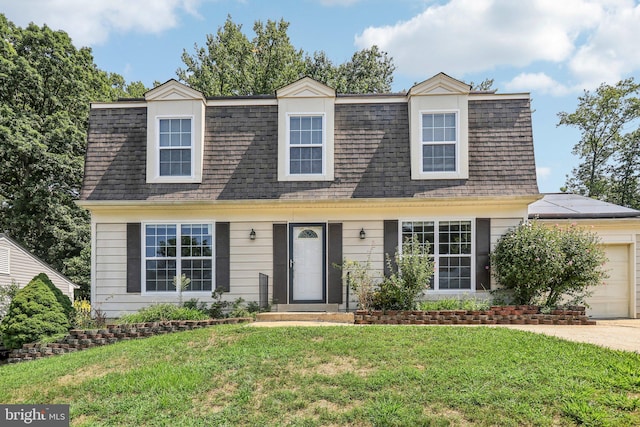 new england style home featuring a garage and a front lawn