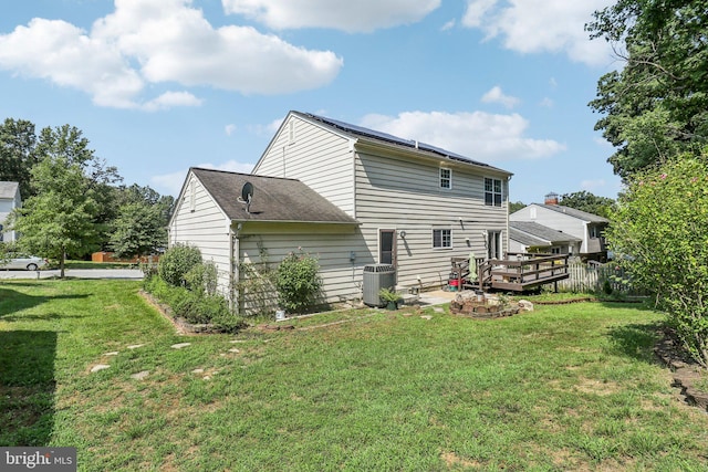 view of side of home with a wooden deck, central AC, and a lawn