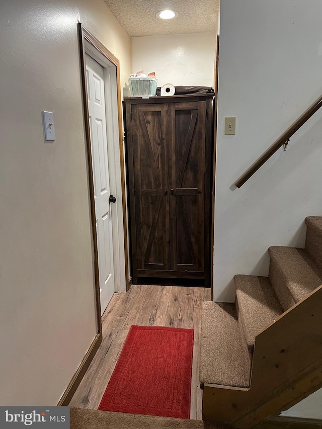 entryway featuring light hardwood / wood-style flooring and a textured ceiling