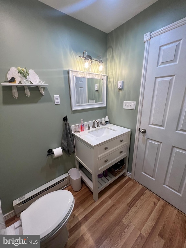 bathroom with baseboard heating, vanity, toilet, and hardwood / wood-style floors