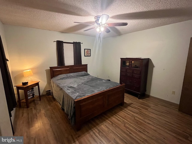 bedroom with a textured ceiling, dark hardwood / wood-style floors, and ceiling fan