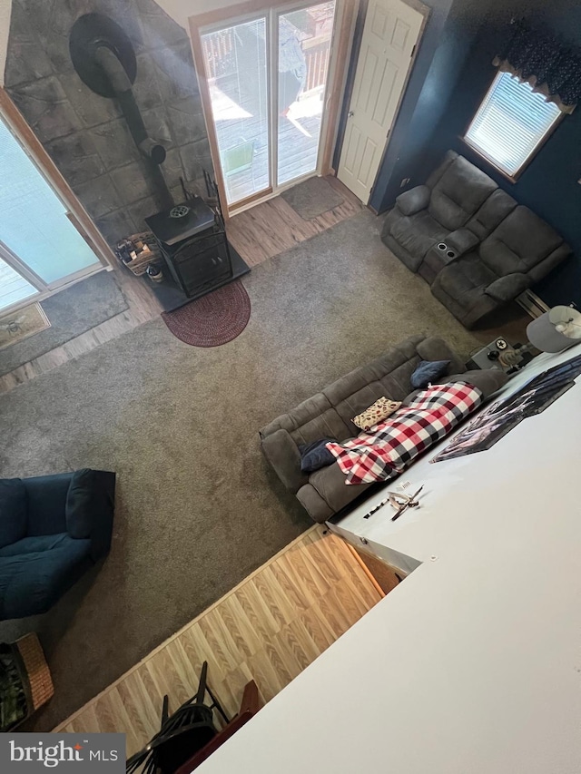 carpeted living room featuring a wood stove