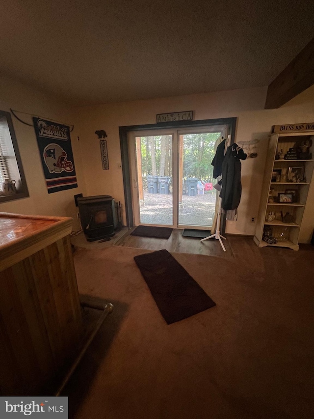 interior space with carpet flooring and a wood stove