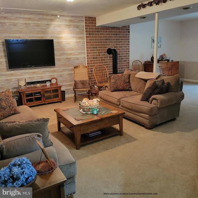 living room with a textured ceiling, brick wall, wood walls, a wood stove, and carpet