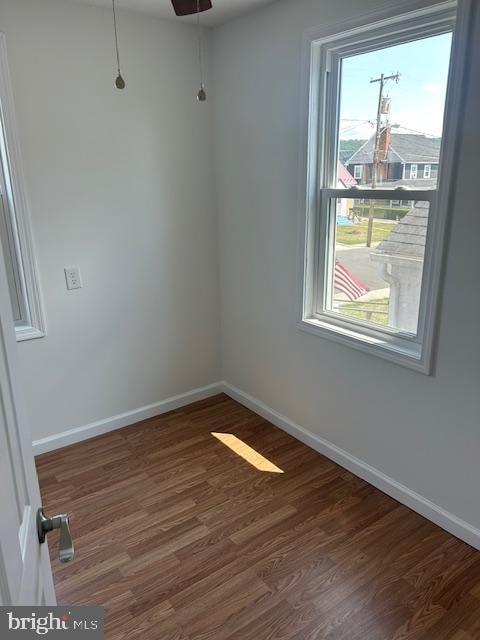 unfurnished room featuring ceiling fan and dark wood-type flooring