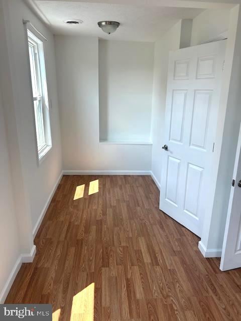 unfurnished room featuring dark wood-type flooring and plenty of natural light