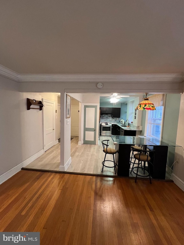 dining space with crown molding and light wood-type flooring