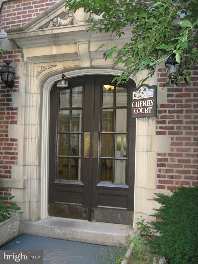 doorway to property featuring brick siding