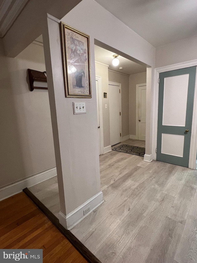 corridor featuring wood finished floors and baseboards