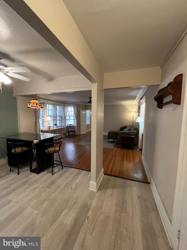 dining space with ceiling fan, baseboards, and wood finished floors