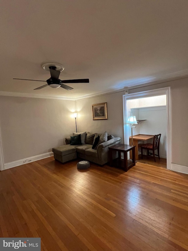 living room featuring light wood-type flooring, baseboards, and crown molding