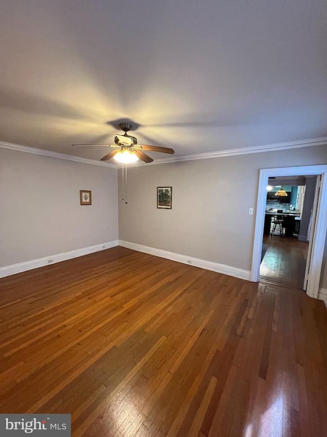 empty room with baseboards, wood-type flooring, a ceiling fan, and crown molding