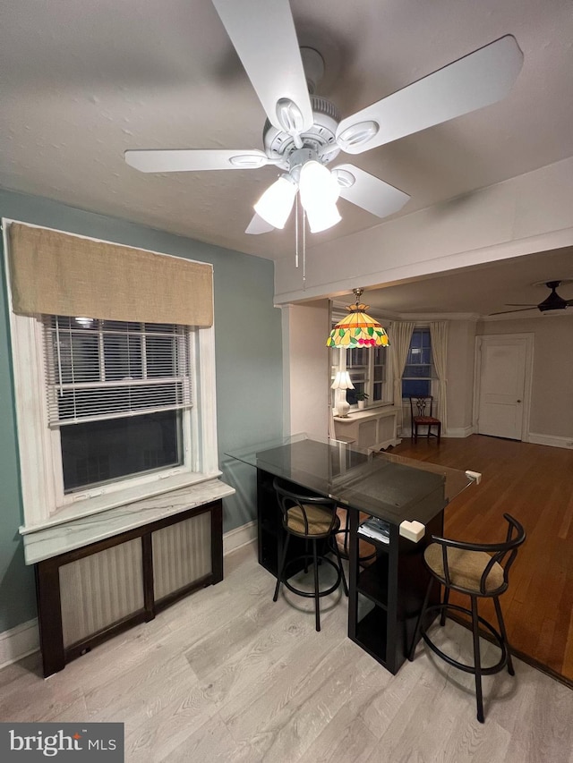 dining area featuring baseboards, wood finished floors, and a ceiling fan