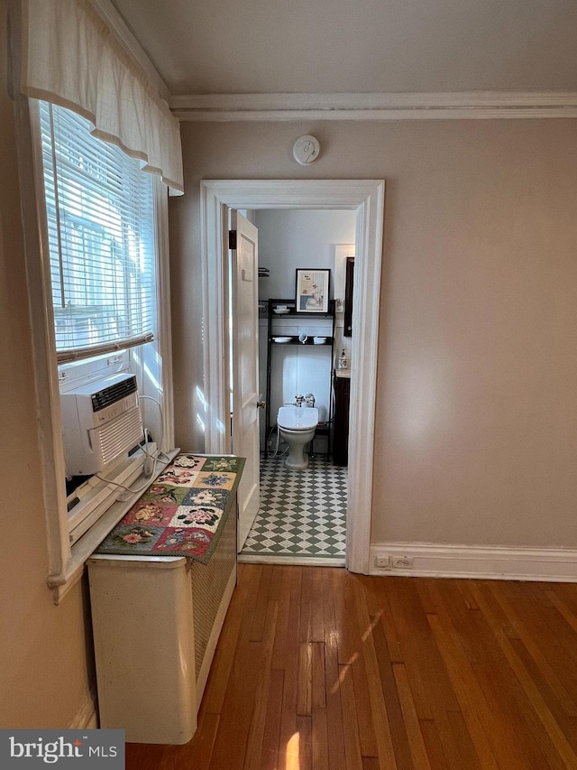 corridor with cooling unit, crown molding, baseboards, and hardwood / wood-style floors