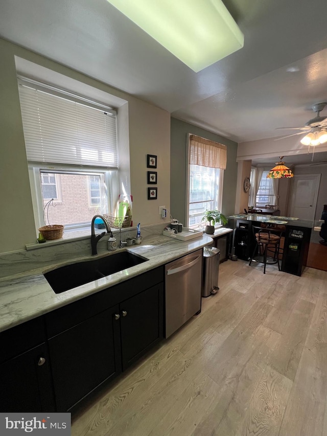 kitchen featuring light wood-type flooring, plenty of natural light, sink, and dishwasher