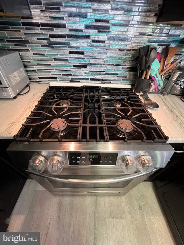 interior details with stainless steel range and hardwood / wood-style floors