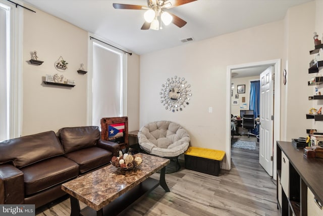 living room with ceiling fan and light hardwood / wood-style flooring