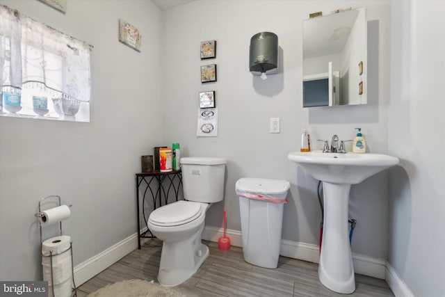 bathroom featuring wood-type flooring and toilet