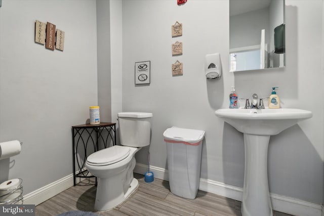 bathroom with toilet and hardwood / wood-style floors