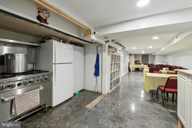 kitchen with stainless steel range, tile patterned floors, and white refrigerator