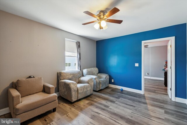 living area featuring ceiling fan and hardwood / wood-style flooring